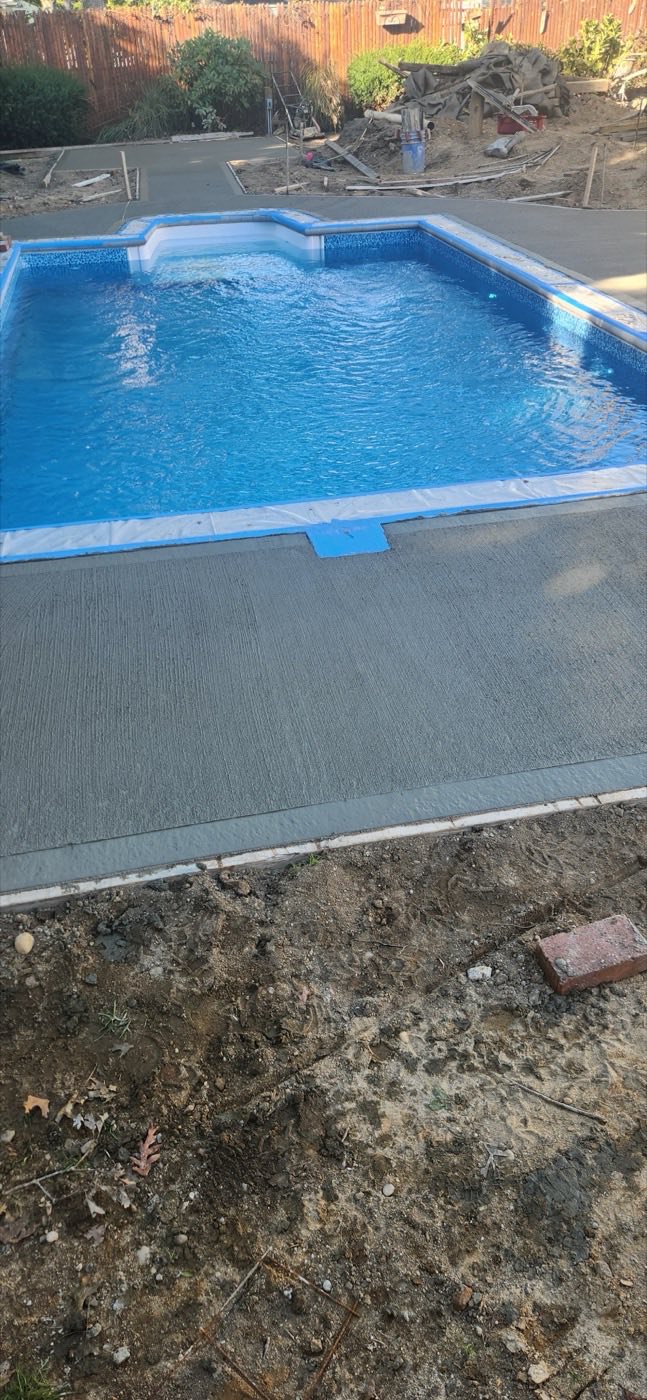 Fresh concrete deck along a blue pool